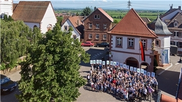 Eine Gruppe von Menschen hält Buchstaben hoch.
