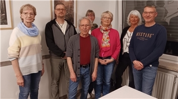 Männer und Frauen stehen in einer Gruppe.