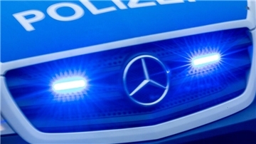 Ein Einsatzfahrzeug der Polizei fährt mit Blaulicht durch die Innenstadt.