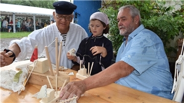 Gezeiten-Wochen in Butjadingen starten mit Mitmachfest für die ganze Familie Zwei Männer und ein Mädchen bauen aus Holz einen Kutter.