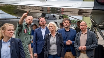 Unter dem wachen Blick einer Security-Mitarbeiterin (von links) erklärt ein Marineflieger Bürgermeister Marcus Itjen, Ministerin Lambrecht, dem SPD-Bundestagsabgeordneten Daniel Schneider und dem stellvertretenden Bürgermeister der Stadt Cuxhaven Oliver Ebken ein Waffensystem.
