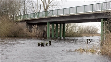 Blick auf eine Brücke mit grünem Geländer.