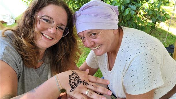 Impressionen aus mittelalterlichem Mulsum: Hartes Ringen beim Wurster Dreikampf Urlauberin Daniela (links) ist glücklich mit ihrem Henna-Tattoo - Marktfrau "La Bruja" hat es ihr auf die Hand gezeichnet.