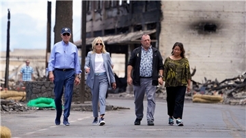 US-Präsident Joe Biden (l) und First Lady Jill Biden (2.v.l) gehen zusammen mit Josh Green, Gouverneur von Hawaii, und seiner Frau Jaime Green durch ein von Waldbränden auf der Insel Maui verwüstetes Gebiet.