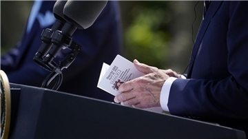 US-Präsident Joe Biden schaut während der Pressekonferenz im Rosengarten des Weißen Hauses auf seine Notizen.