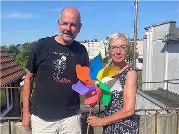 Paar mit Windrose in der Hand auf einem Balkon