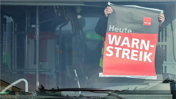 Ein Mann hängt ein Plakat in einem Bus auf, darauf steht: "Heute Warnstreik". Verdi ruft zu Warnstreiks auf: Beschäftigte der KVG Stade wollen am 14. Mai ab 10 Uhr am Betriebshof in Cuxhaven demonstrieren.