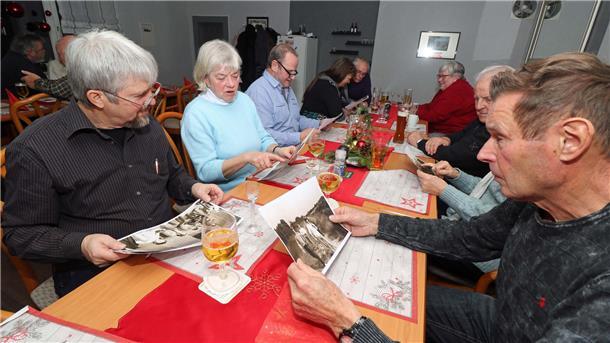 Langjährige Mitglieder des TSV Uthlede kramen beim Betrachten von historischen Fotos in ihren Erinnerungen. 