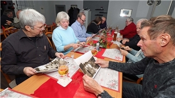 Langjährige Mitglieder des TSV Uthlede kramen beim Betrachten von historischen Fotos in ihren Erinnerungen. 