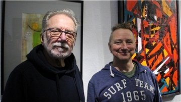Zwei Männer stehen vor einem Bild