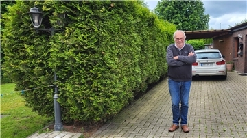 Nordenham: Darum will die Stadt auf einmal 18.350 Euro von diesem Hausbesitzer Ein Mann steht mit verschränkten Armen auf seiner Hauseinfahrt.