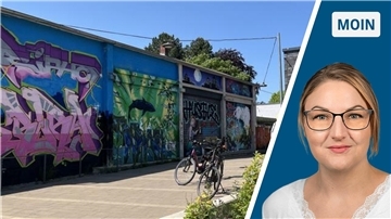 Zwei Fahrräder, die vor einer Graffitifassade stehen. 