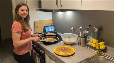Frau steht in der Küche und kocht.