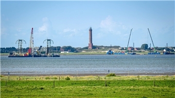 Windstrom durchs Watt leiten: Wie wird Norderney unterbohrt? Vom Festland aus ist das Kabelverlegeschiff „Barbarossa“ im Watt vor Norderney zu sehen.