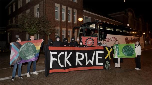 Menschen stehen vor einem Bus. 