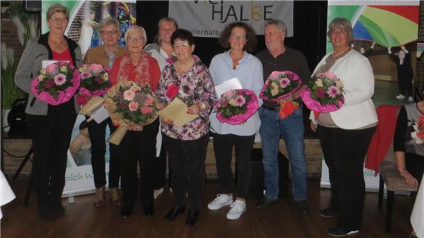 Die geehrten halten Blumensträuße in den Händen und haben sich zum Gruppenfoto aufgestellt.