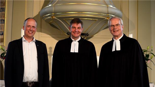 Der Vorsitzende der Kirchenkreissynode, Pastor Markus Stamme (Selsingen), Pastor Carsten Stock und Pastor Gerhard Schäfer (St. Libtorius) stehen nebeneinander vor der Kanzel.