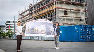 Vor dem Erweiterungsbau des Deutschen Auswandererhauses zeigen Direktorin Dr. Simone Eick (links) und die wissenschaftliche Mitarbeiterin für die Erweiterung des Hauses, Lina Falivena, wie es später aussehen soll.