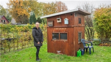 Faszination Igel: Schiffdorferin ist eine tierische Heldin Frau im Garten neben einem Gartenhaus, auf dem "Igelhaus" steht.