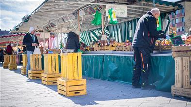 Vor den Marktständen weisen Schilder und Bodenmarkierungen auf die Abstandsregel zur Rücksichtnahme hin. Sie bieten auch Schutz im Osteransturm.