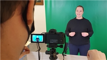 Vor einer grünen Wand spricht Museumspädagogin Katja Tiltmann die Texte für die ersten Lernvideos ein, die das Aeronauticum - vor allem für Schüler - produziert.