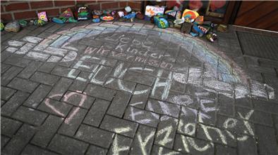 Vor einer Kindertagesstätte ist der Schriftzug „Liebe Kinder, wir vermissen Euch, Eure Erzieher“ auf den Boden geschrieben. Eltern stellen die geschlossenen Kitas vor noch größere Probleme.