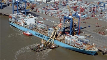 Ein Spezialschiff und zwei Schlepper arbeiten an der Bordwand eines Containerschiffes in Bremerhaven.