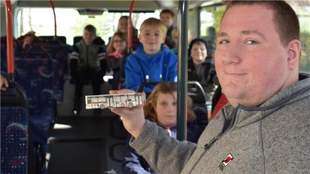 Während des Unterrichts im Bus zeigt Busfahrer Sebastian Jacobs den Kindern auch ein aus einem Bastelbogen gefertigtes Busmodell.