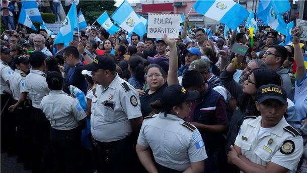 Während einer Demonstration in Guatemala-Stadt hält eine Frau ein Schild mit der Aufschrift „Parasiten raus“ in die Höhe. Tausende Menschen protestieren in dem lateinamerikanischen Land gegen die Generalstaatsanwaltschaft.