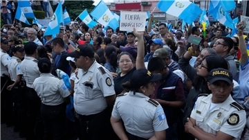 Während einer Demonstration in Guatemala-Stadt hält eine Frau ein Schild mit der Aufschrift „Parasiten raus“ in die Höhe. Tausende Menschen protestieren in dem lateinamerikanischen Land gegen die Generalstaatsanwaltschaft.