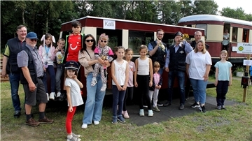 Fahrgäste warten darauf, in das Schienenbus-Modell „Kalli“ einsteigen zu können. 