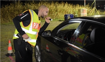 Großkontrolle am Wesertunnel: Einsatzleiter Marius Masia blickt mit der Taschenlampe ins Innere eines Fahrzeugs. 