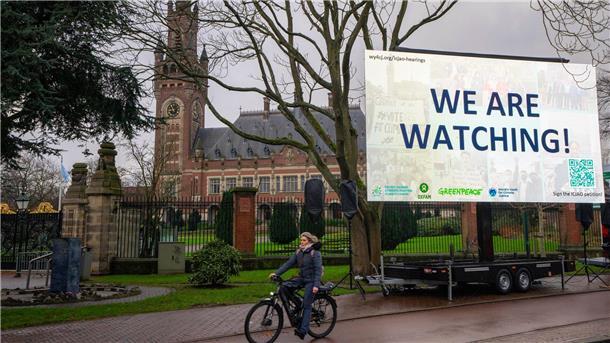 UN-Gericht: Versäumnisse beim Klimaschutz völkerrechtswidrig „We are Watching!“ ist auf einem Plakat vor dem Internationalen Gerichtshof zu lesen: Das höchste UN-Gericht hat sich mit Klimaschutz befasst. (Archivbild)