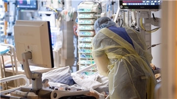 Ein Krankenpfleger versorgt einen Menschen auf der Intensivstation.
