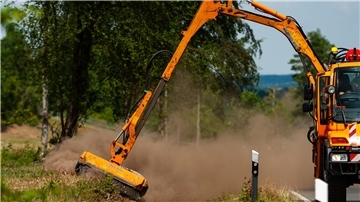 Mit einem Unimog wird der Grünstreifen an einer Kreisstraße gemulcht.