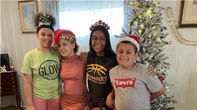 Covid, Orkane und ein bisschen Hoffnung Eine amerikanische Familie steht vor einem Weihnachtsbaum.
