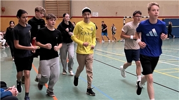 Jugendliche laufen durch eine Sporthalle