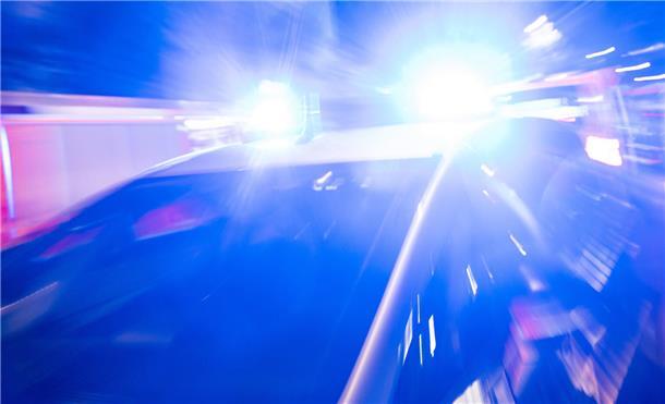 Ein Polizeiauto fährt mit Blaulicht.