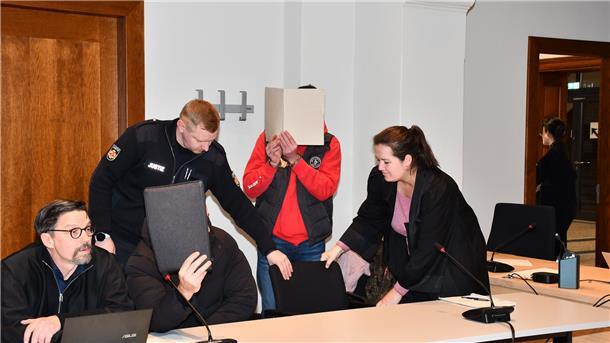 Kokainschmuggel in Bremerhaven: Gericht verhängt hohe Haftstrafen Angeklagte mit Heften vor dem Gesicht neben ihren Anwälten