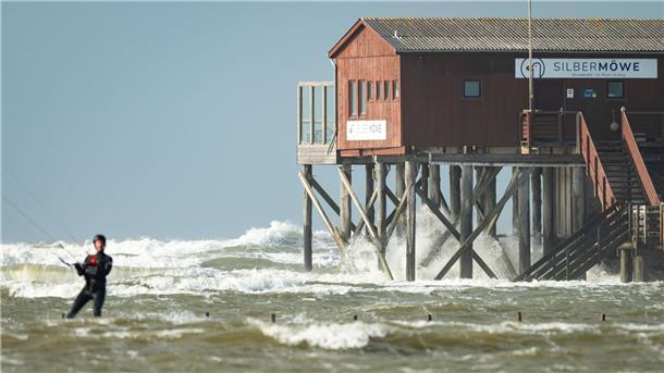 Wellen peitschen an die Pfähle eines Restaurants am Strand von St. Peter Ording. (Archivbild)