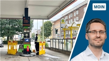Eine Zapfsäule an einer Tankstelle. Die Zapfsäule ist abgesperrt. Ein Mann und Absperrbaken stehen davor.