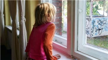 Ein Kind steht am Fenster