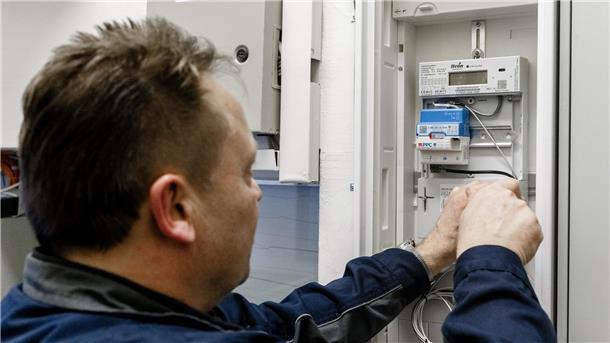 Smart Meter auf dem Vormarsch: Was Sie dazu wissen müssen Ein Elektriker montiert einen digitalen Stromzähler mit einem Smart-Meter-Gateway zur Datenübertragung.