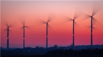 Die Rotoren von Windkraftanlagen drehen sich nach Sonnenuntergang.