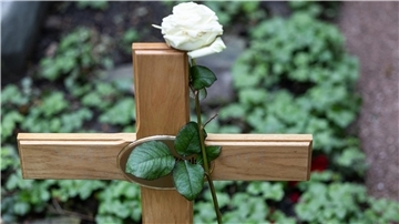 Holzkreuz auf Grab.
