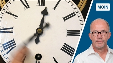 Jemand dreht an einer Uhr. KZW-Reporter wartet derweil auf seinen neuen Zaun.