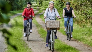 Drei Frauen fahren Fahrrad.