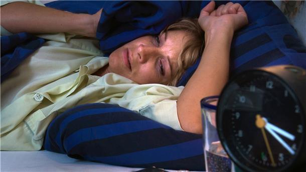 Eine Frau liegt im Bett.