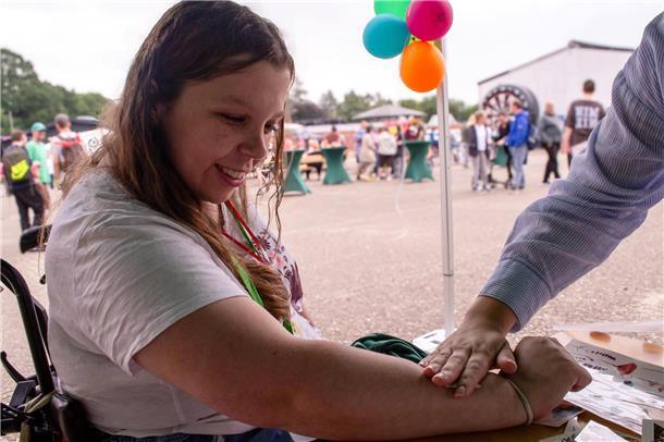 Werkstatträtin und Beschäftigte Julia Zimmermann lässt sich ein Glitzer-Tattoo aufkleben.