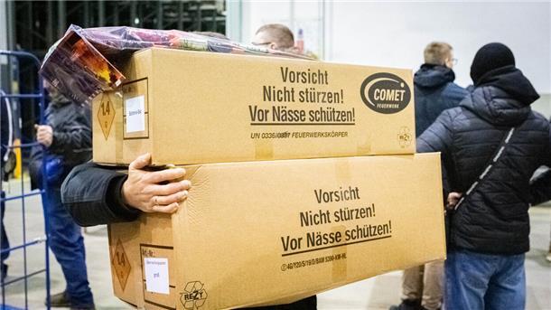 Ein Mann schleppt Kartons. 